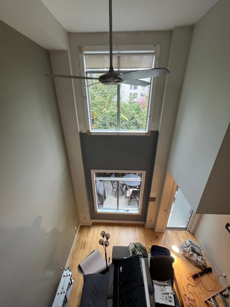 Lofted-ceiling condo living room in Kelowna before interior painting